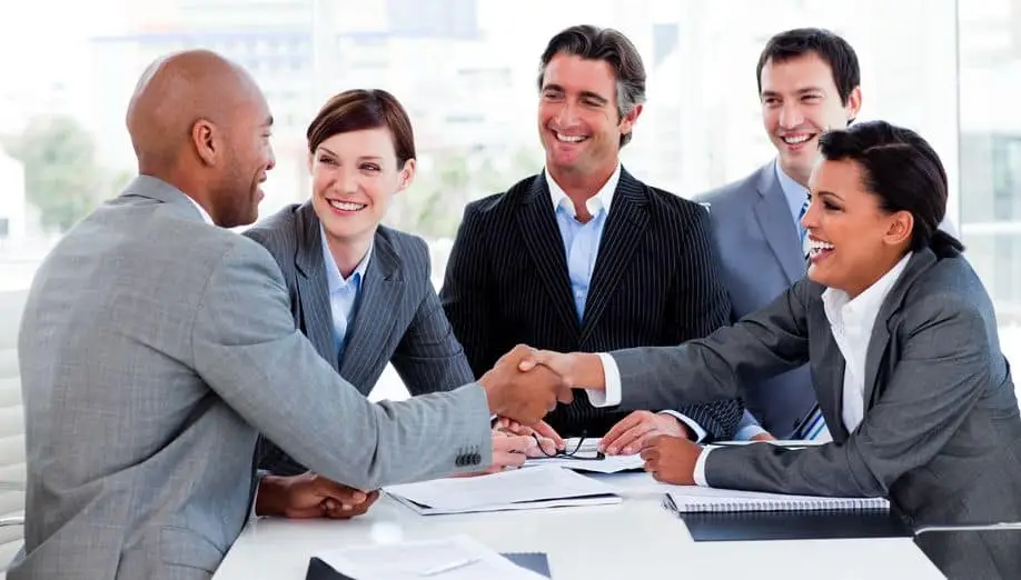 Diverse business team smiling and shaking hands in a meeting