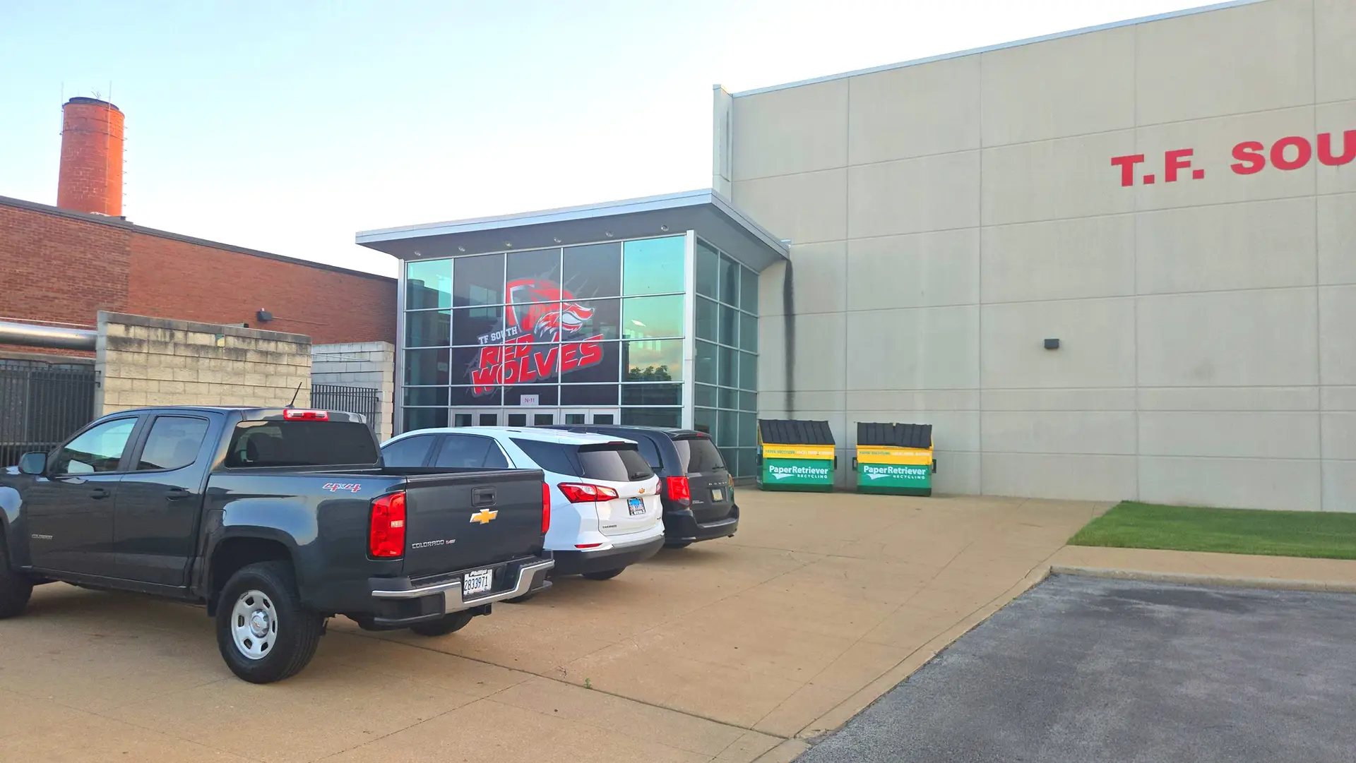 Entrance of T.F. South High School with parked cars