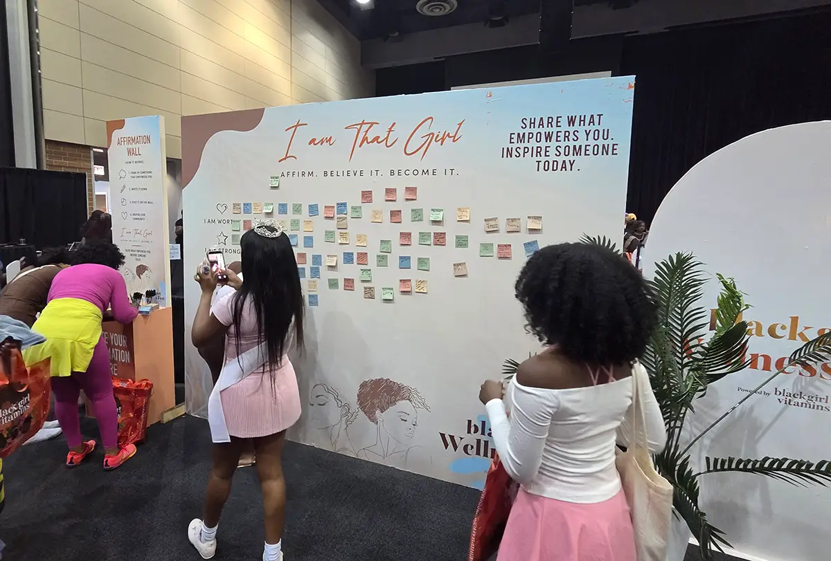 'I Am That Girl' affirmation wall at expo with sticky notes