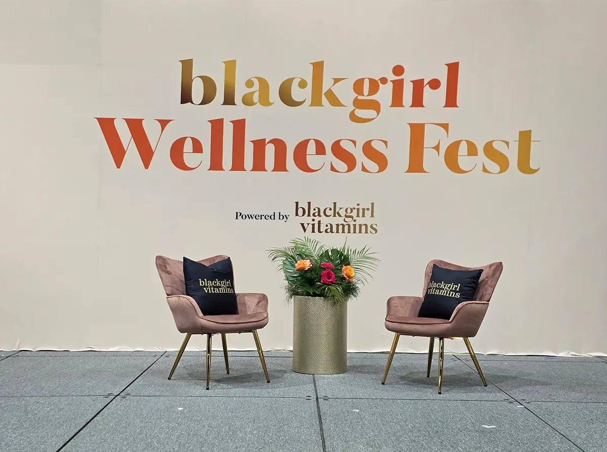 Two chairs at Black Girl Wellness Fest with cushions and floral decor