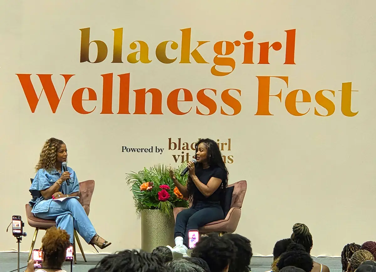 Panel discussion at Black Girl Wellness Fest with two women speaking on stage